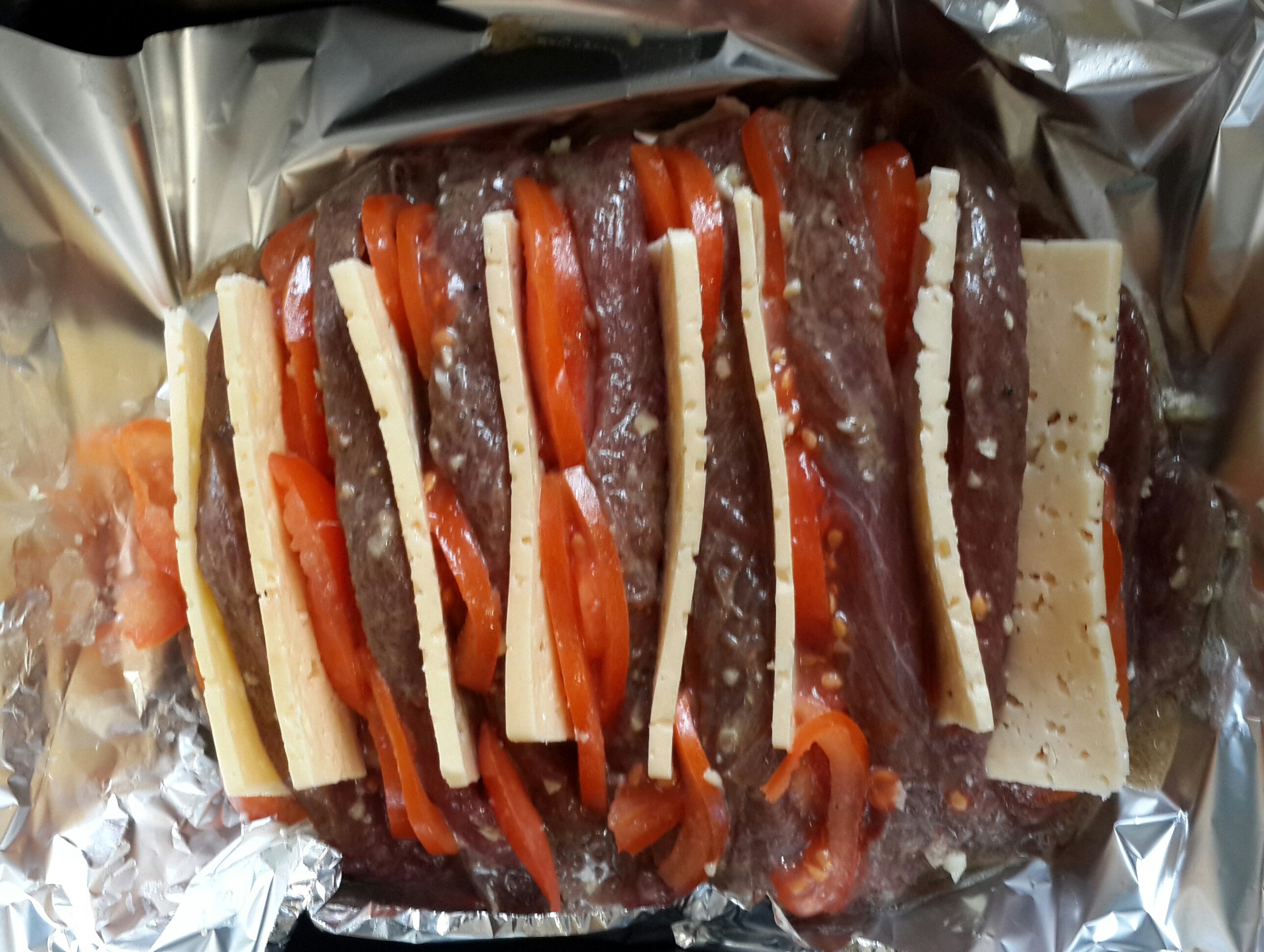 Мясо, запеченное гармошкой с сыром и помидорами